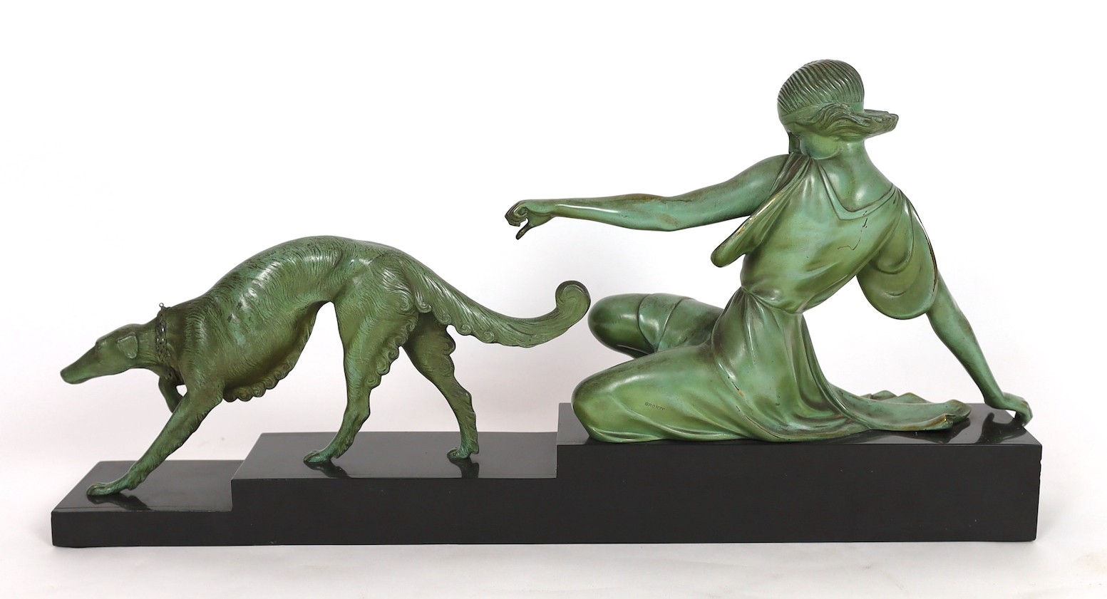 Armand Godard. A French Art Deco patinated bronze and black marble group of a classical woman and borzoi, 80cm wide, 37cm high